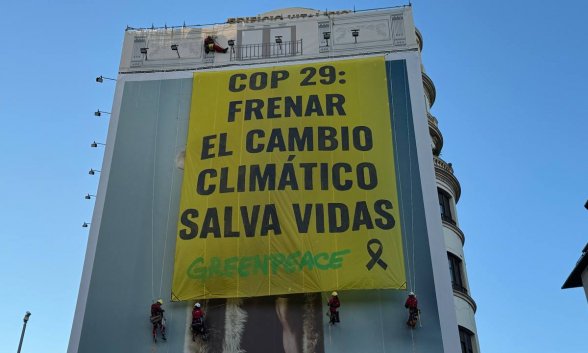 Greenpeace cuelga una pancarta en Madrid, ante el inicio de la COP29 en Bakñu